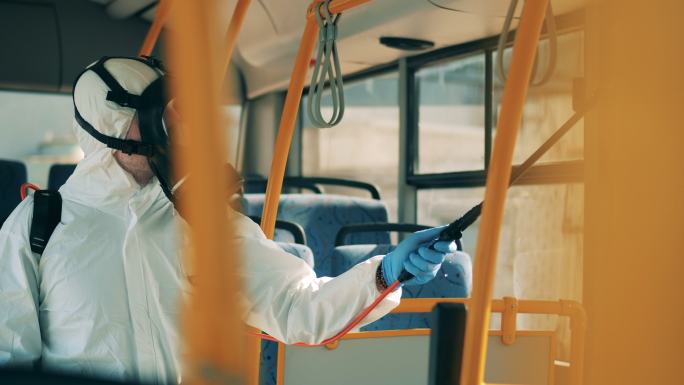 一名环卫工人正在对公交车进行消毒。