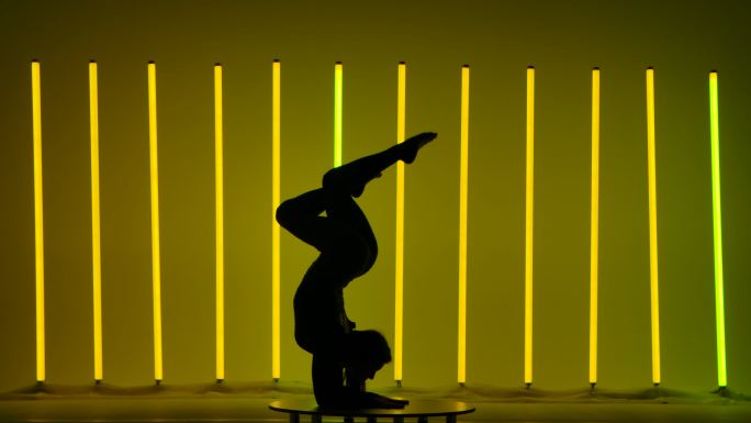 运动员在霓虹灯的背景下表演体操。