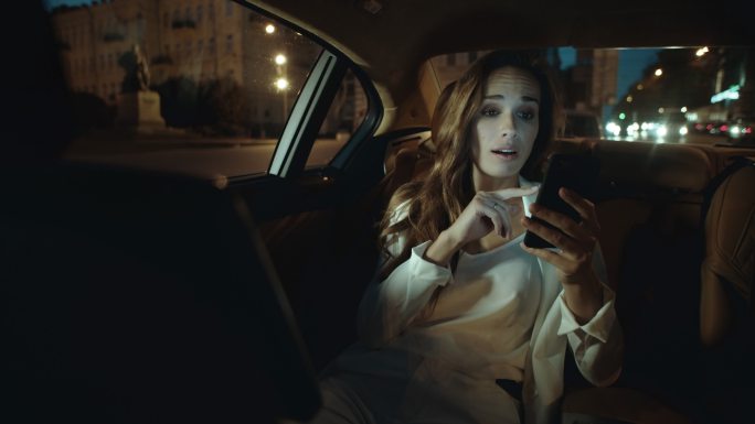 女士在车里用智能手机进行视频聊天