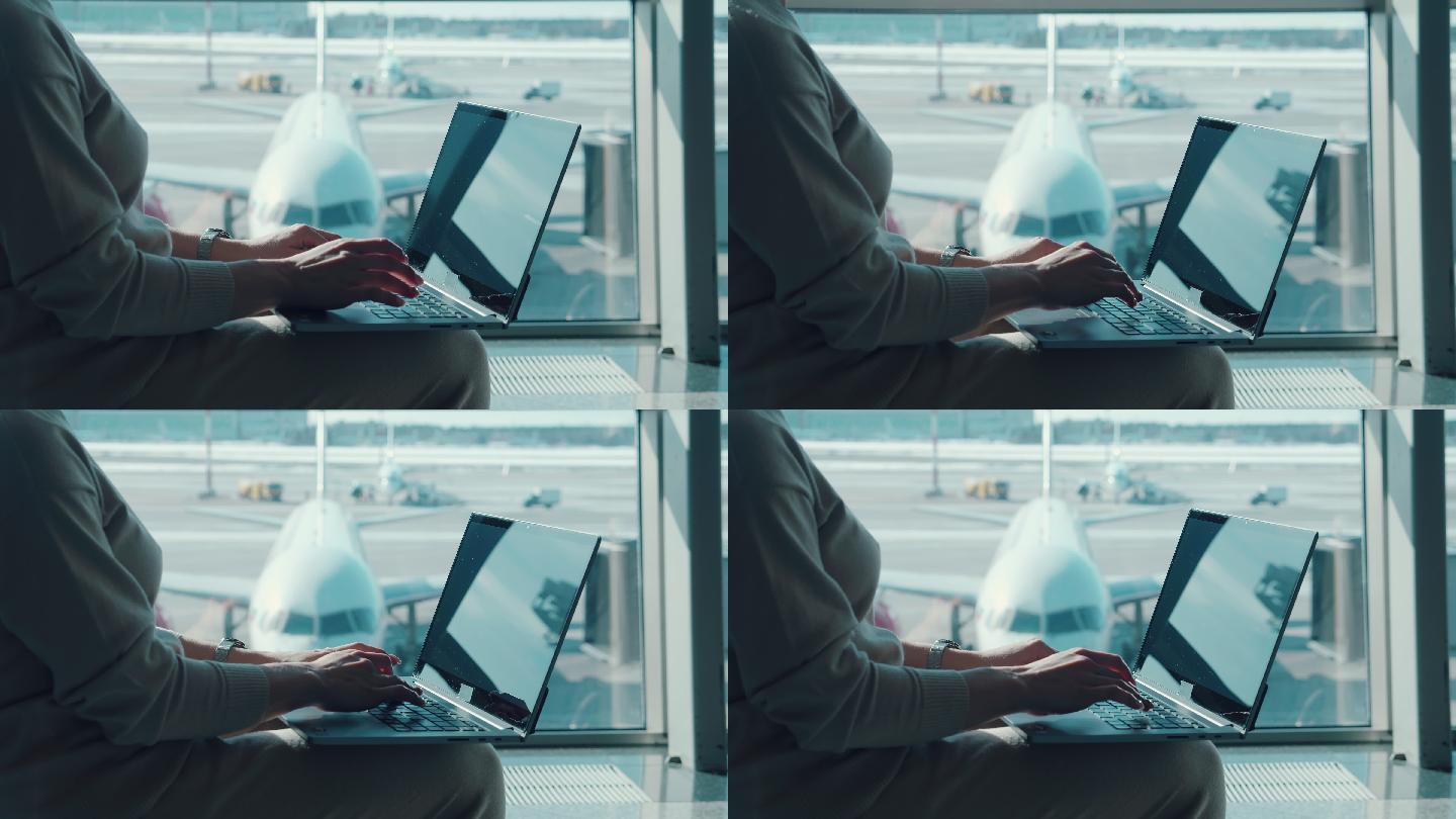 一名女子正在机场候机室的笔记本电脑上打字