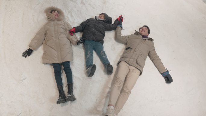 冬天一家躺在雪地上玩雪