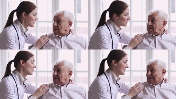年轻的护士搂着微笑的退休老人的肩膀。