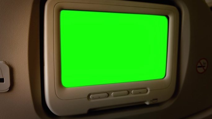在飞机乘客座椅上安装绿色屏幕的显示器。
