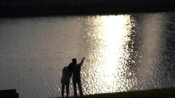 情侣在湖边看夕阳
