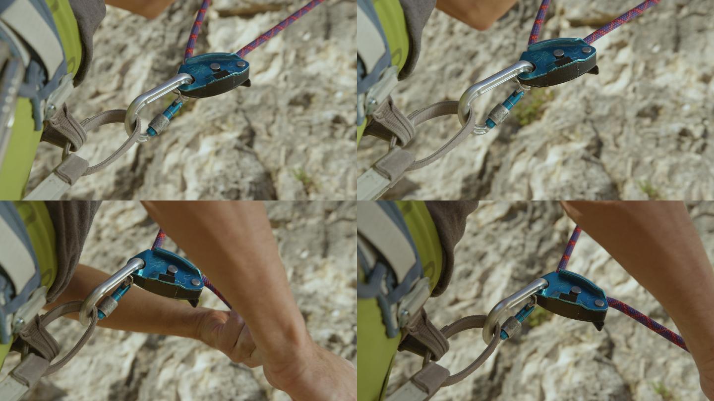 男子在保护同伴攀岩时调整绳索。