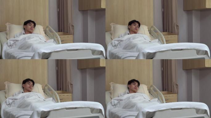 年轻男子躺在床上看着医院