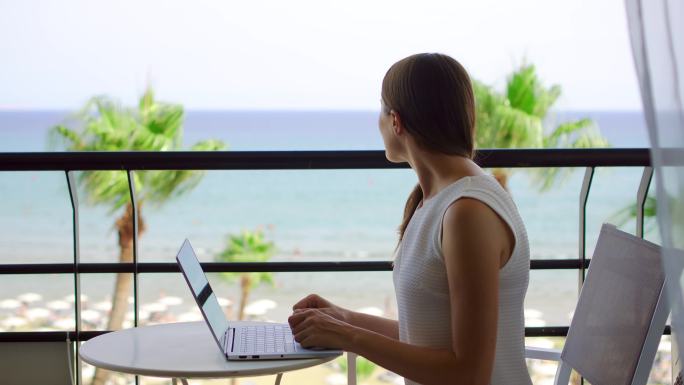 热带海滩度假村用笔记本电脑工作的女商人