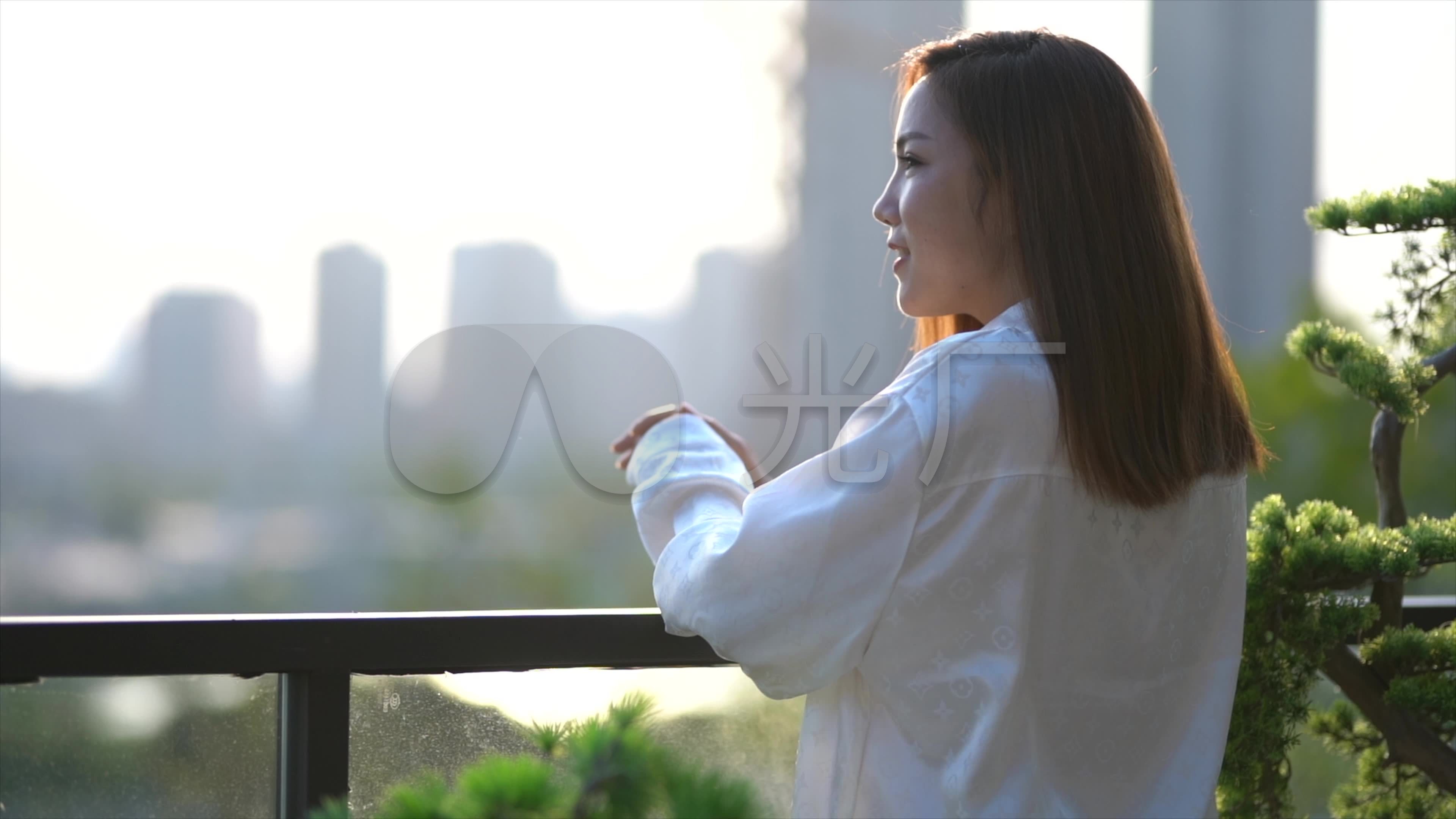 快乐的年轻女子在阳台上拍照-蓝牛仔影像-中国原创广告影像素材