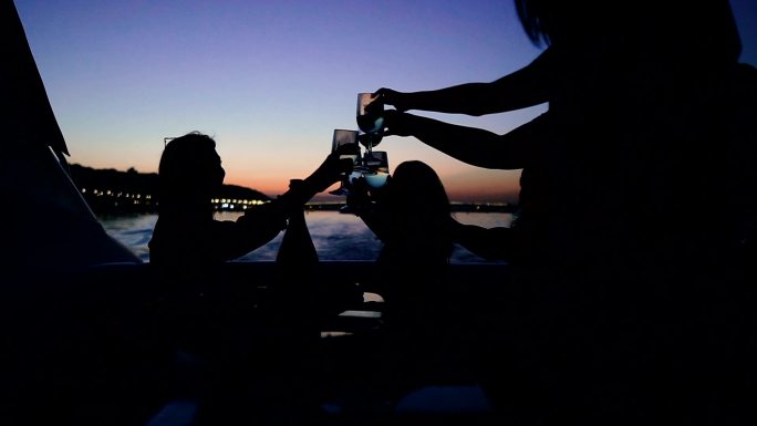 游艇上喝酒的人的剪影。