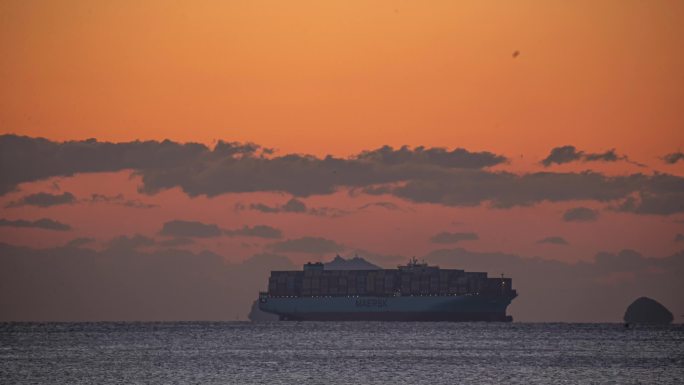 日出时的海面上的大船和海岛