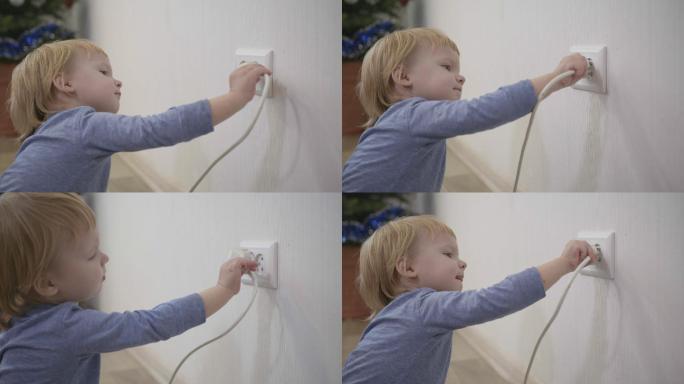 小男孩试图将电源插头插入电源插座