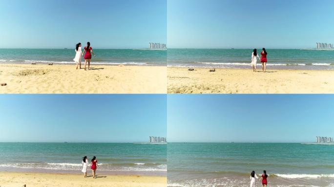 两美女向海边跑去