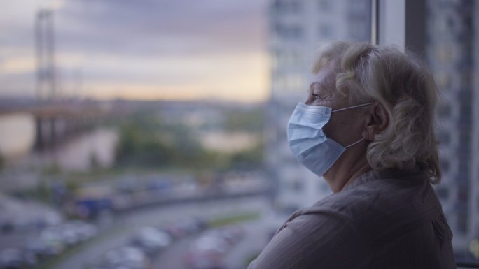受感染的老年患者站在医院窗口