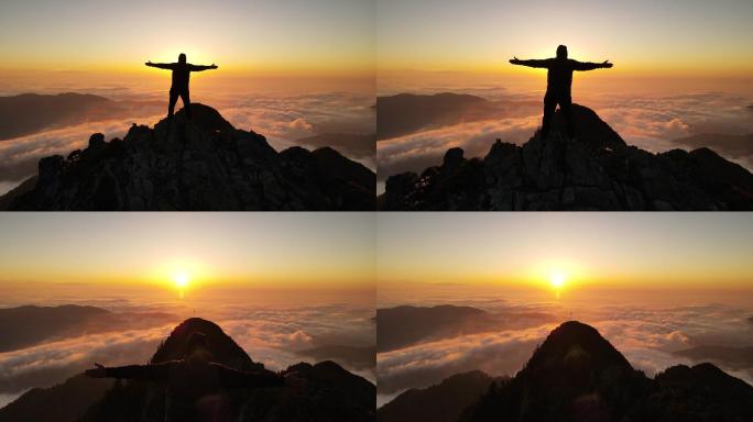 男人在云雾之上的山峰上观看日落。