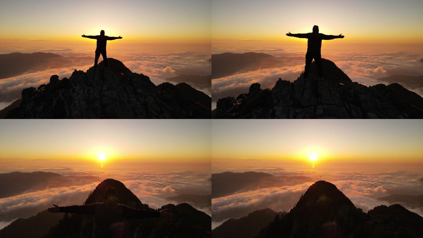 男人在云雾之上的山峰上观看日落。