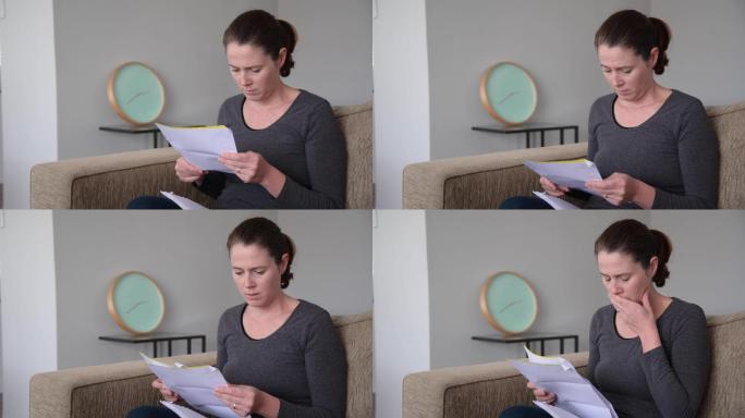 震惊的成年女子在客厅读一封信