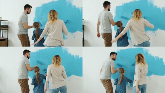 一家人在家里开心地粉刷墙壁