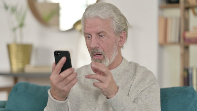 疑惑的老年人使用手机
