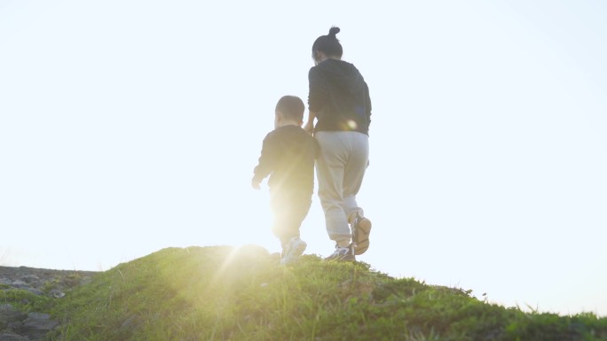 温馨牵手妈妈牵着小孩户外行走陪伴孩子成长