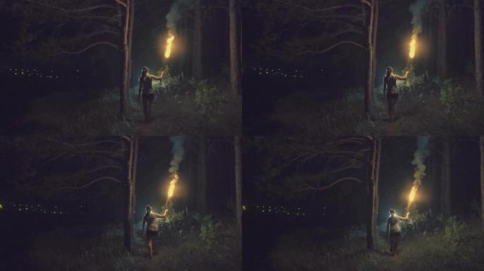 女孩拿着火炬在森林边缘奔跑