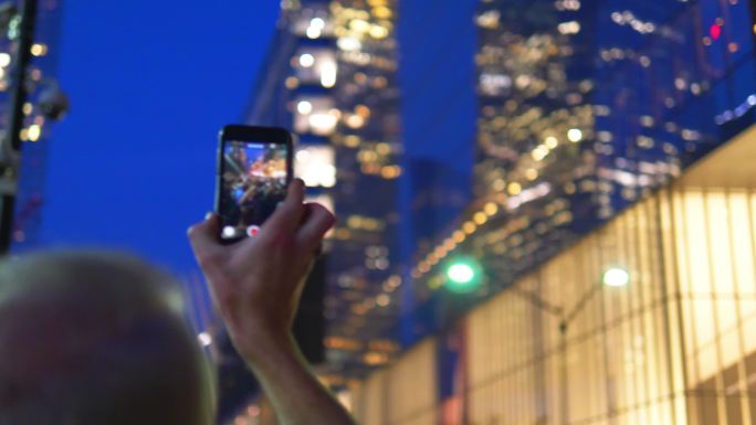 游客在城市里用智能手机拍照