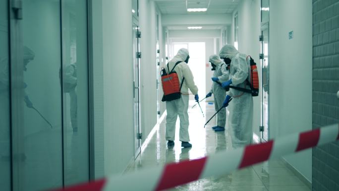 危险品区的工作人员用防腐剂对走廊进行消毒