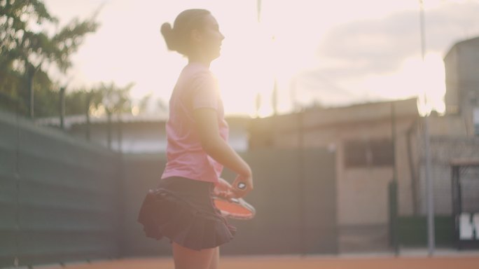 女子用网球拍使劲打网球。