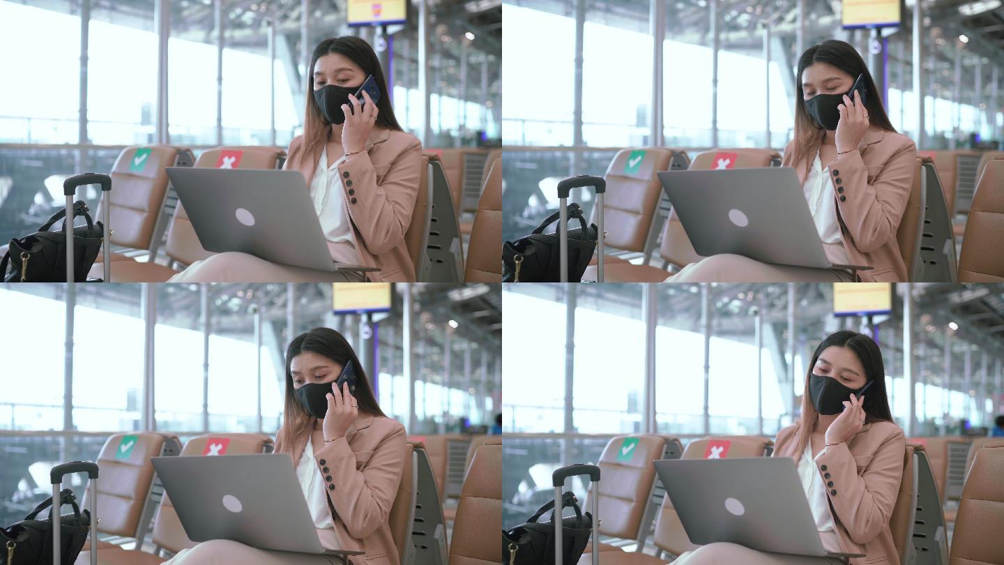 女商人在机场用笔记本电脑工作。