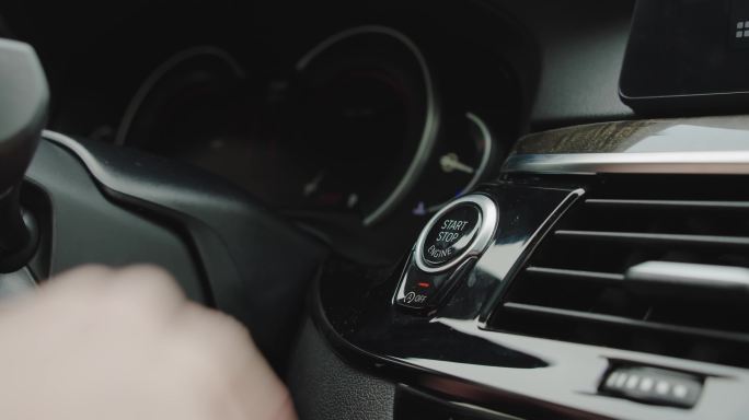 用手指按下按钮启动汽车发动机。