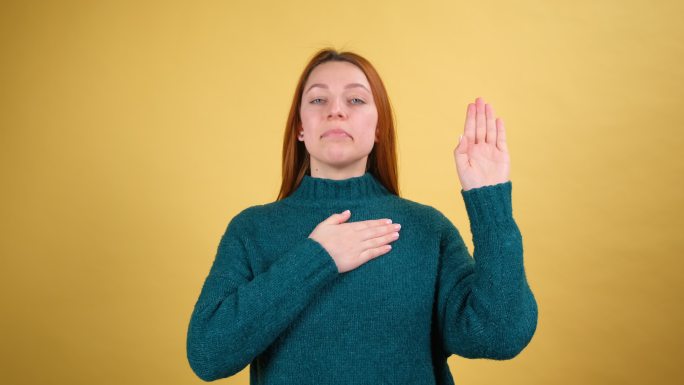 诚实负责的年轻女子举手，抚摸胸膛许下誓言