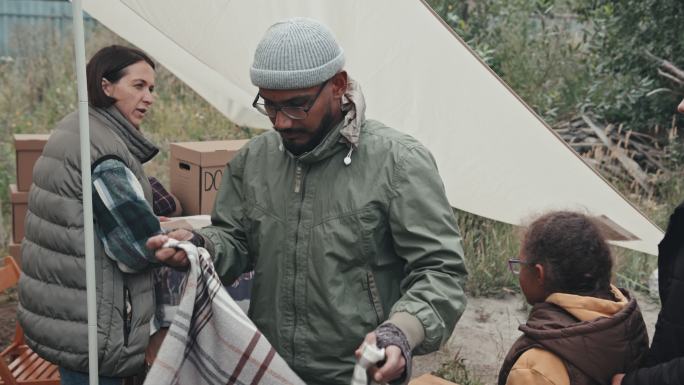 社会工作者给难民提供温暖的毯子