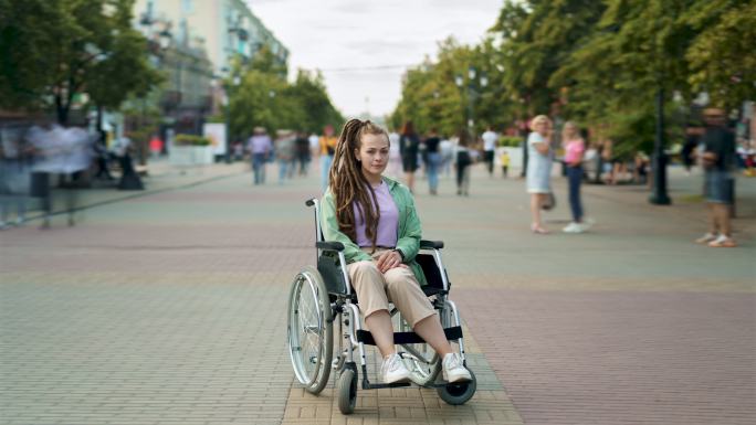 残疾女子坐在轮椅上看着摄像机