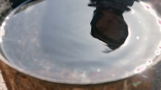 一个小男孩的身影倒映在一碗水里