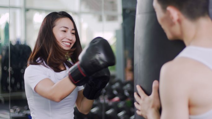 教练指导教学女运动员在体育馆打沙袋