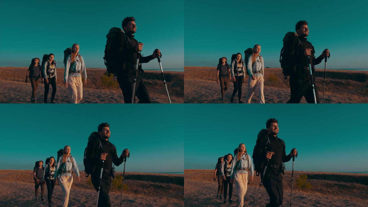 四个年轻人背着背包在海边旅行。
