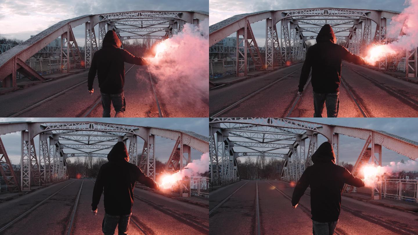 男人在一座旧钢架桥上拿着燃烧信号弹