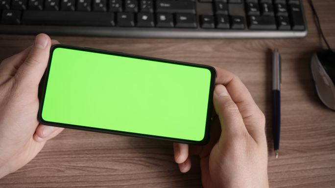 男子在带有绿色屏幕的智能手机上扫描纹