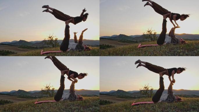 情侣在山顶上练习复杂的瑜伽