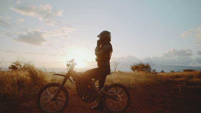 美丽的年轻女子骑着自行车看日落