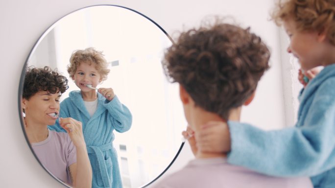 年轻女子和小男孩在浴室刷牙