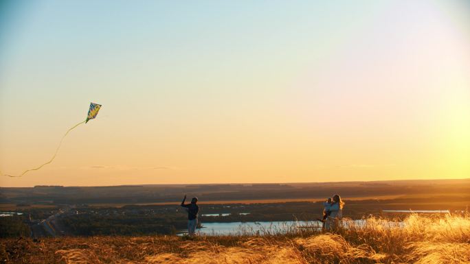 日落时分，一家人在麦田上玩风筝