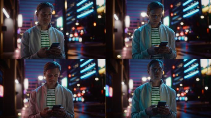 男人用智能手机在夜市街道上行走