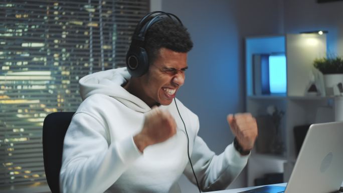 戴耳机的玩家在电脑上赢得在线游戏