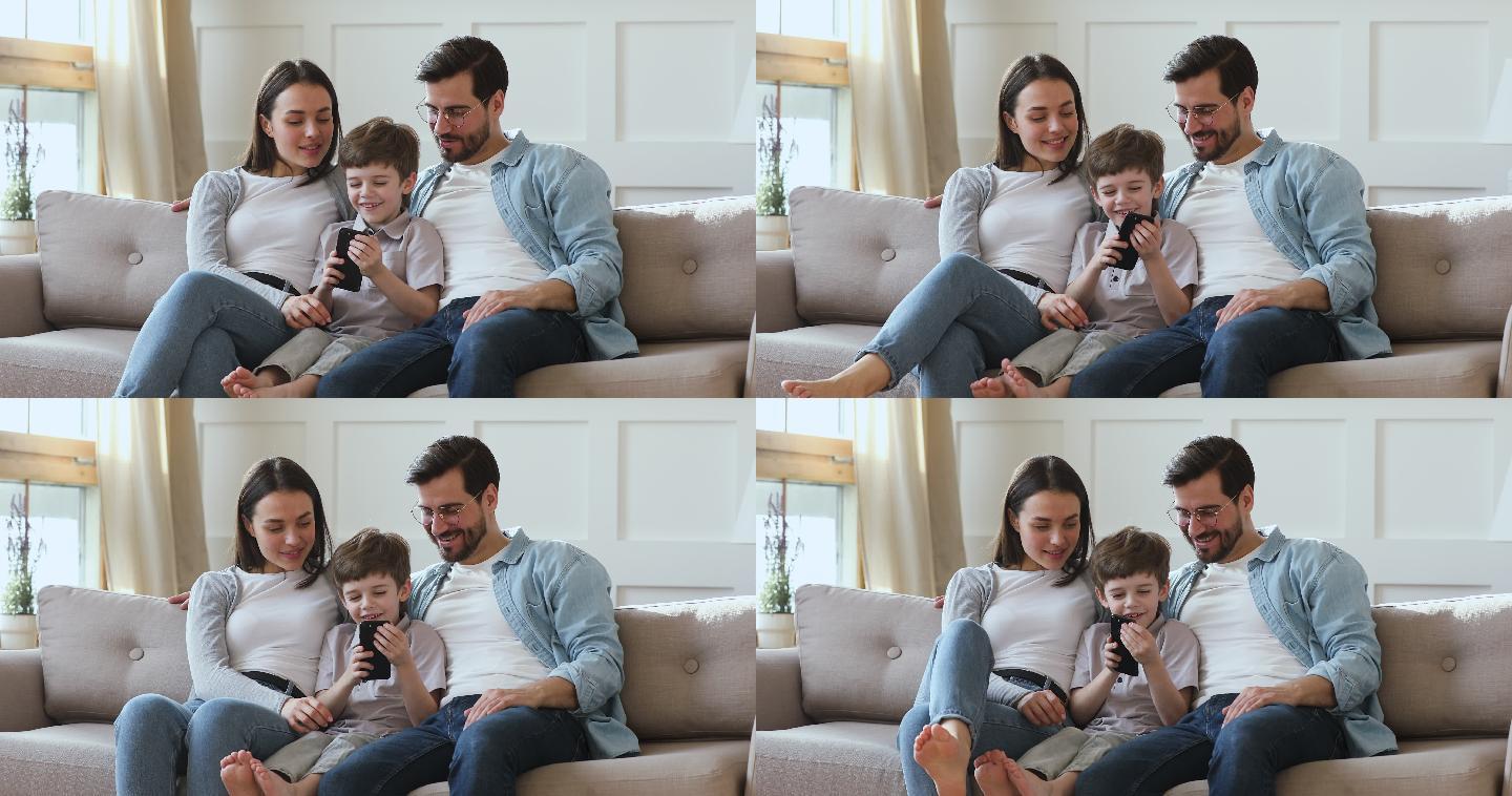 快乐的小男孩和父母玩手机游戏。