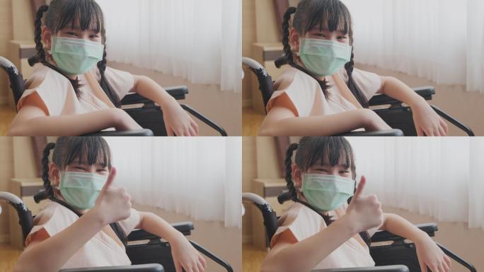 坐在轮椅上戴口罩住院的女孩竖起大拇指。