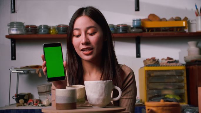 女陶艺家展示绿屏手机