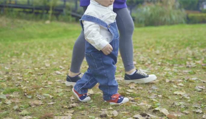 亲子陪伴，幸福家庭，妈妈小孩走草地上特写