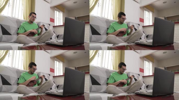 快乐的男人坐在沙发上学习如何弹奏四弦琴