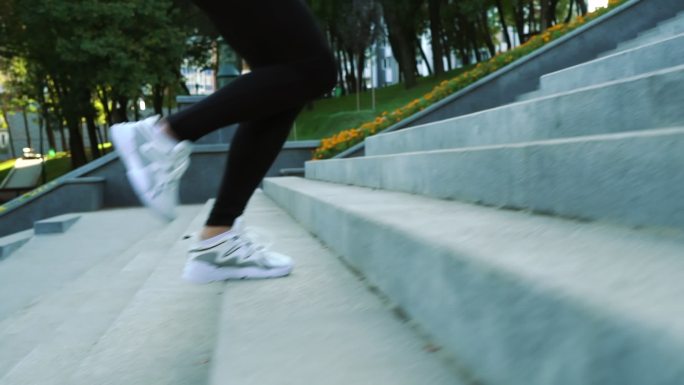 穿着运动鞋在城市楼梯上慢跑的女性