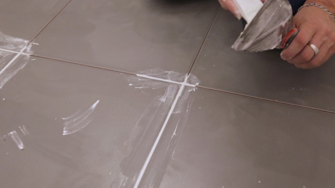 工人抹平地板瓷砖之间的接缝